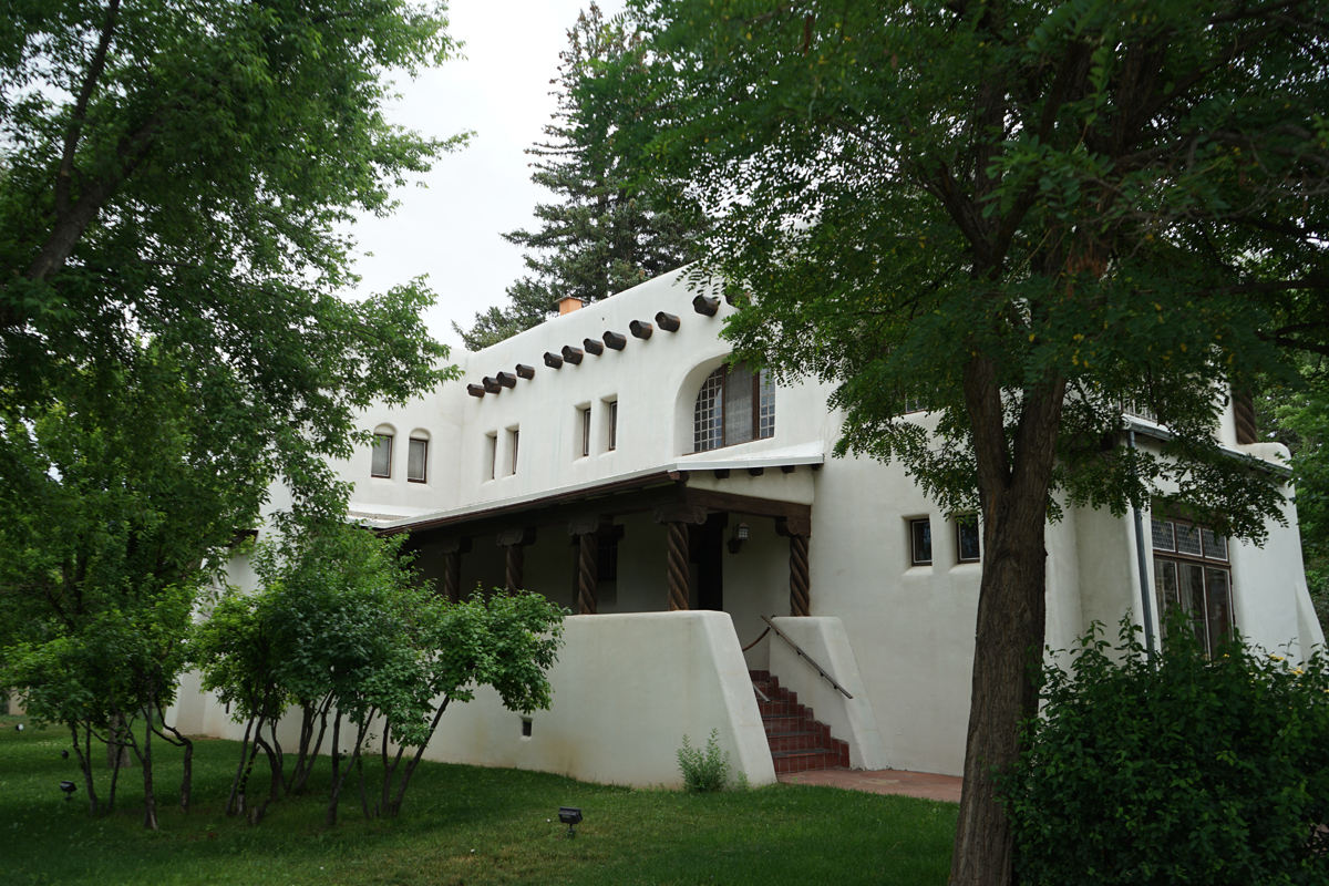 The Nicolai Fechin House in Taos, New Mexico, which stewards the historic home and studio of the Russian artist, is a two-level adobe structure painted white.