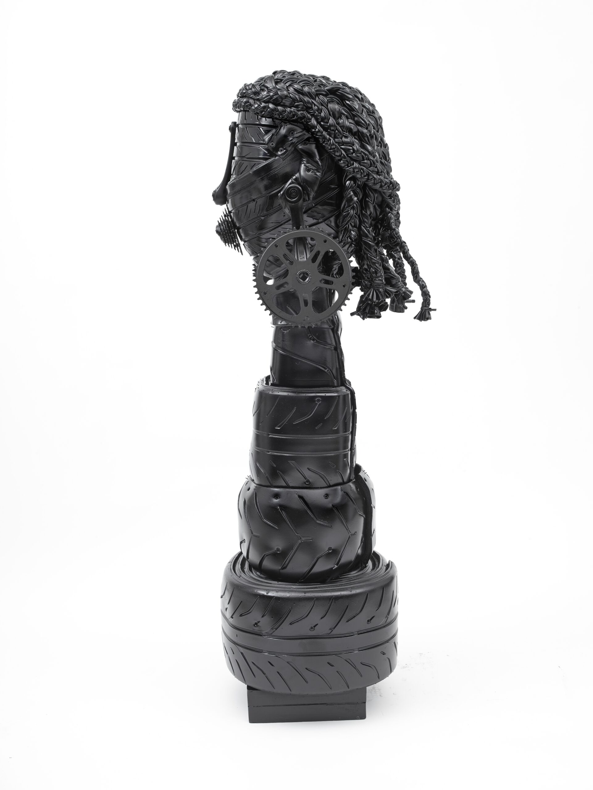 A neatly stacked sculpture by Kim Dacres made from shiny black found materials, depicting Sojourner Truth.