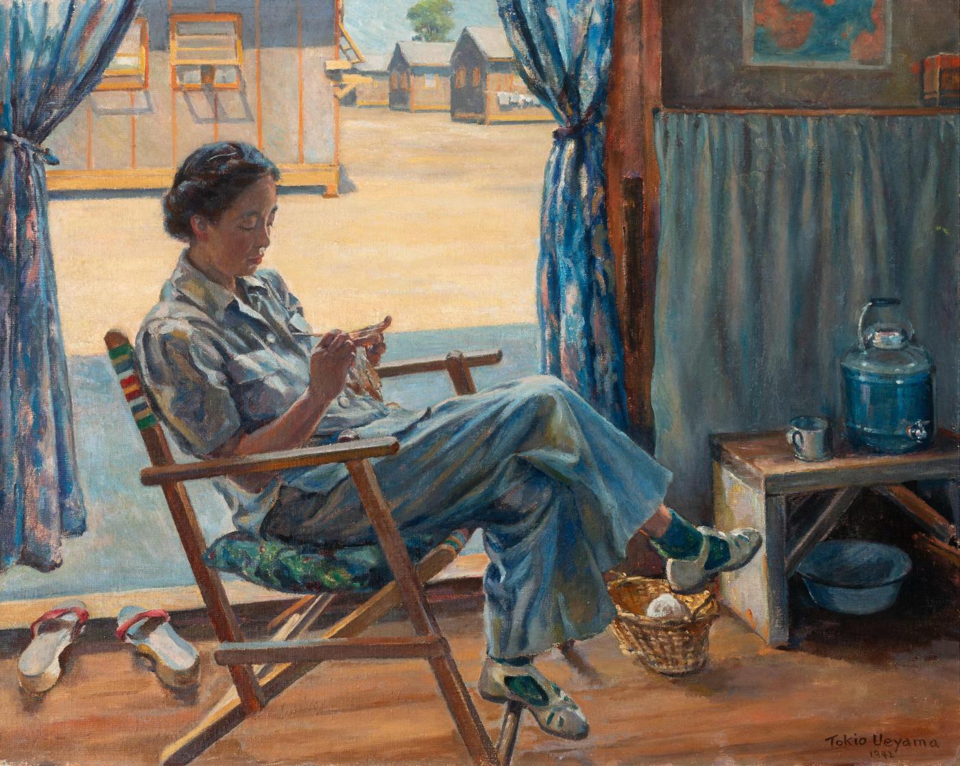 A Japanese American woman hand-paints a small object inside a barrack at a Japanese American incarceration camp. This painting by Tokio Ueyama is one of the top Southwest art exhibitions to see this summer.