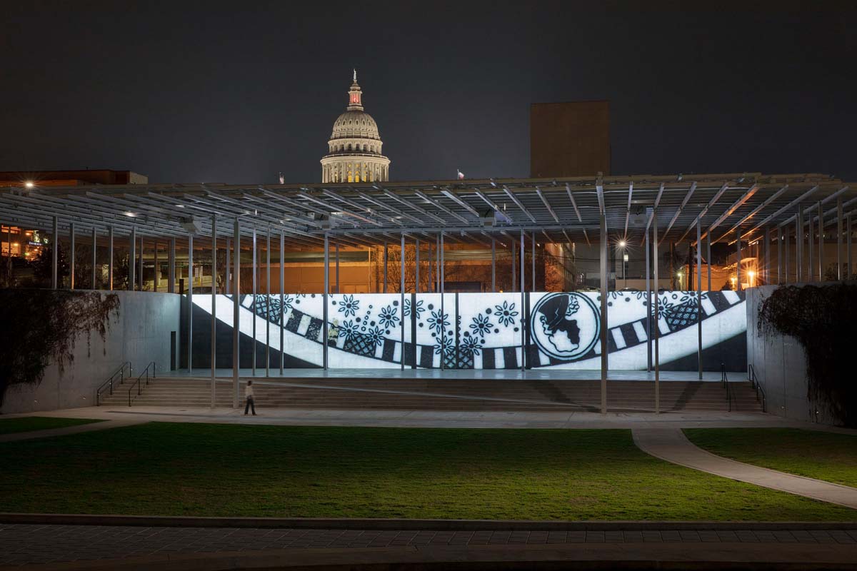 View of the video installation Past Deposits from a Future Yet to Come with the Austin State Capitol in the background.