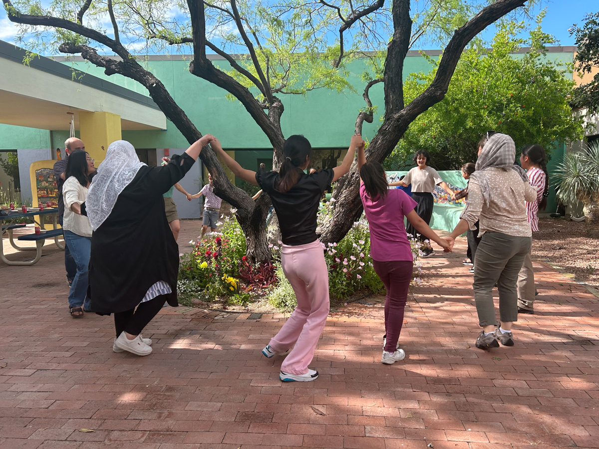 A group of students dancing in a circle at the Tucson Museum of Art.