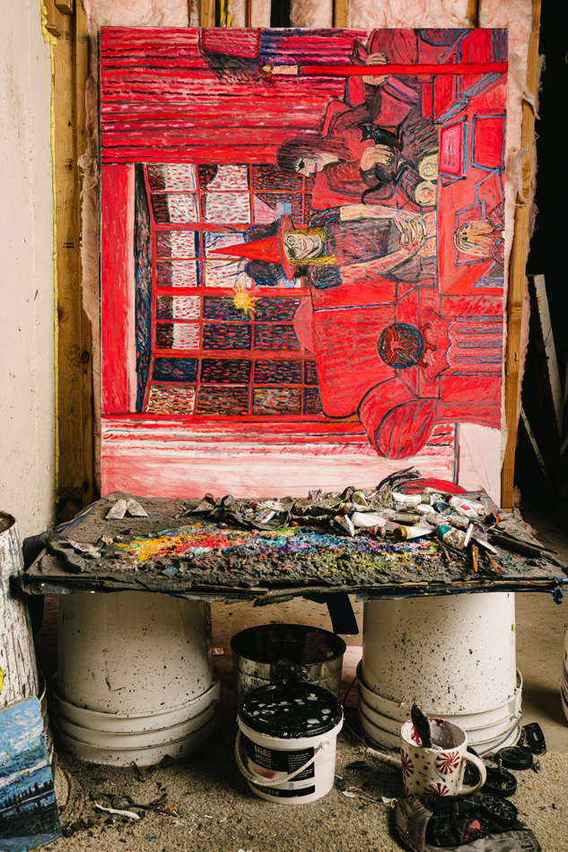 A painting of an interior scene in vivid red, perched on buckets in Lydia Farrell's studio.