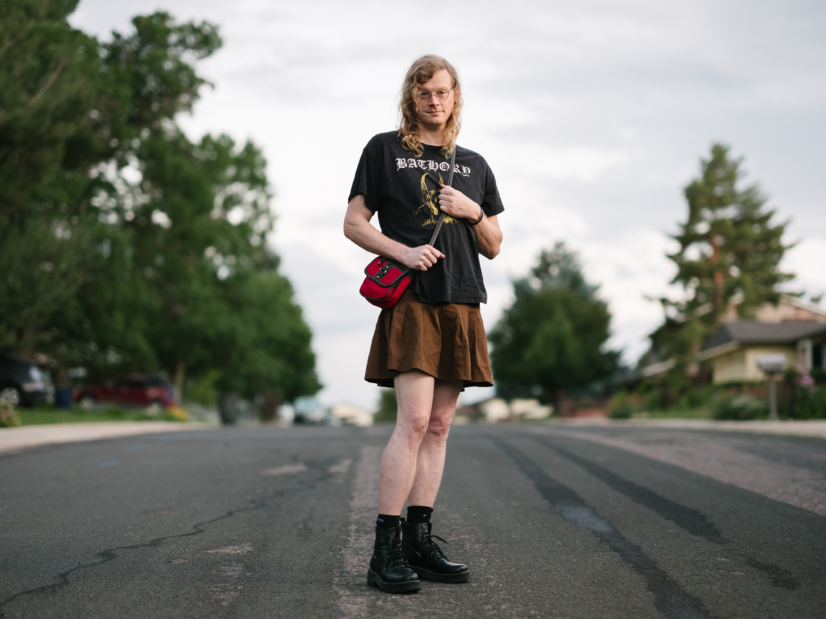 A person clutches a small red satchel on the tree-lined streets of suburban Colorado.