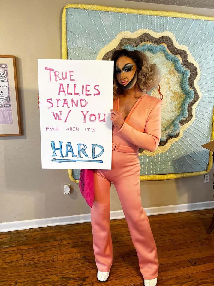 Drag queen Cindi TV holding a sign reading "True Allies Stand W/ You Even When It's Hard."