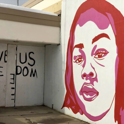 Portrait of Breonna Taylor, a victim of police violence, on a white wall in a red-and-pink palette. The Fleet Block Murals are in Salt Lake City, Utah.