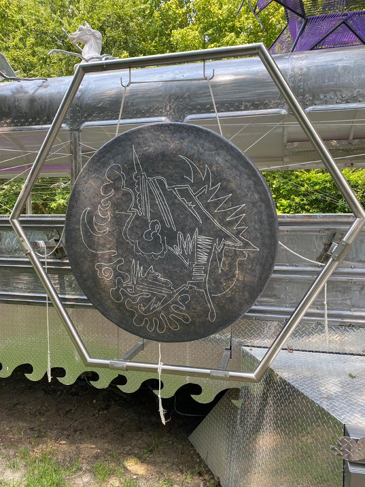 Biomorphic metallic sculptural elements including an etched gong, made from found materials and attached to a chrome bus. Detail of Guadalape Maravilla's interactive, kinetic bus sculpture Mariposa Relampago.