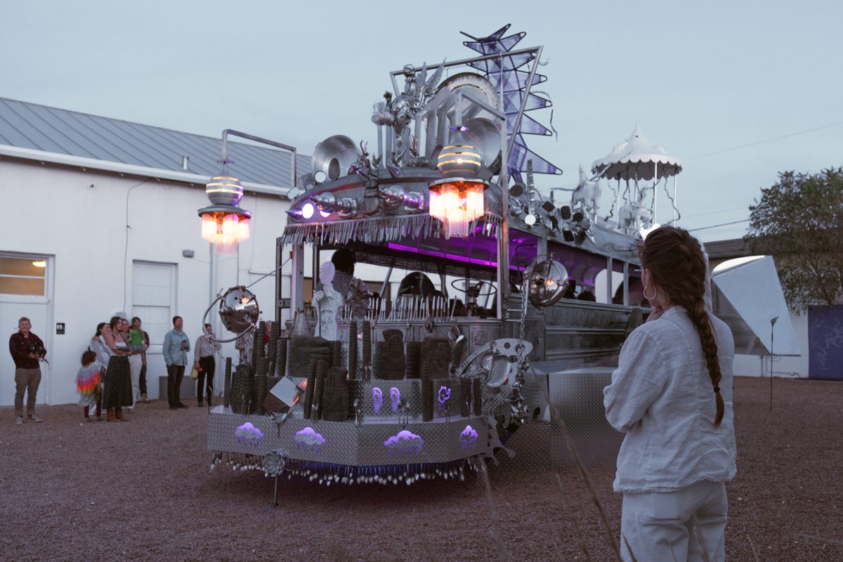 A chrome bus with purple lighting and biomorphic elements. Guadalupe Maravilla Mariposa Relampago is a musical, winged bus with its own migration narrative.