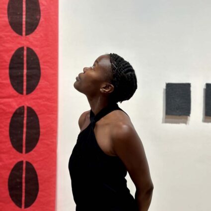 Artist Wabwila Mugala with her works on view in Reclaiming Hope: Afrofuturist Visions at The Gallery at Tempe Center for the Arts