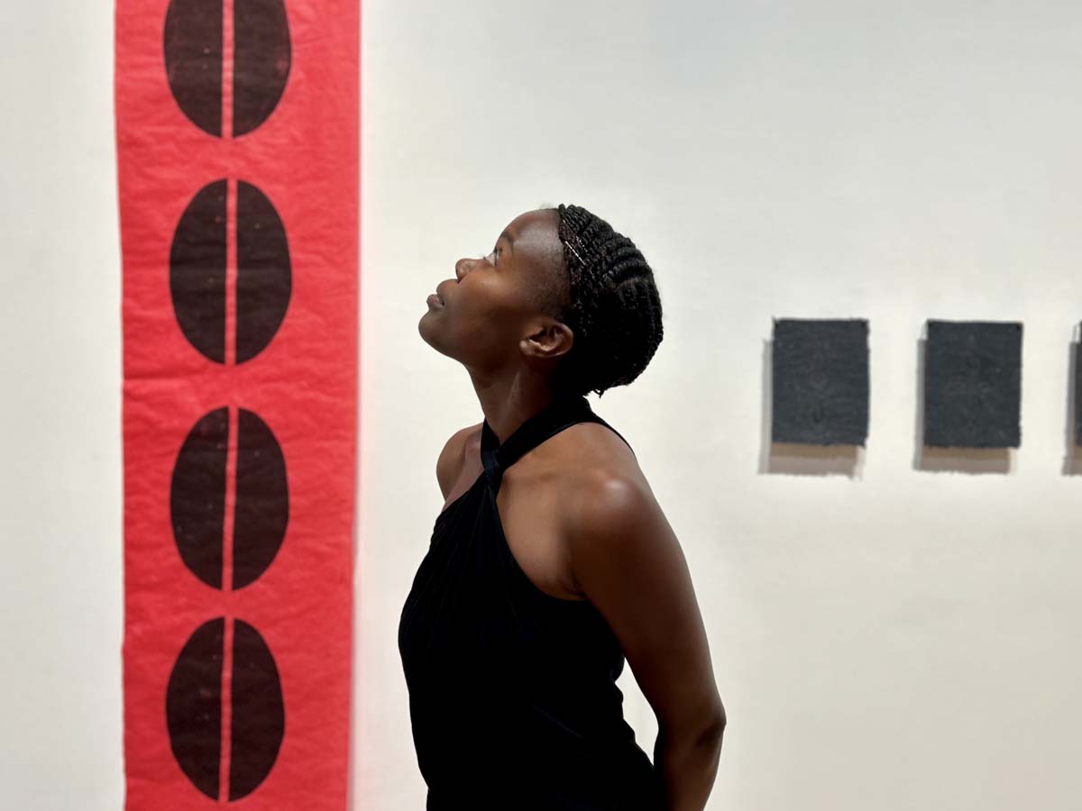 Artist Wabwila Mugala with her works on view in Reclaiming Hope: Afrofuturist Visions at The Gallery at Tempe Center for the Arts