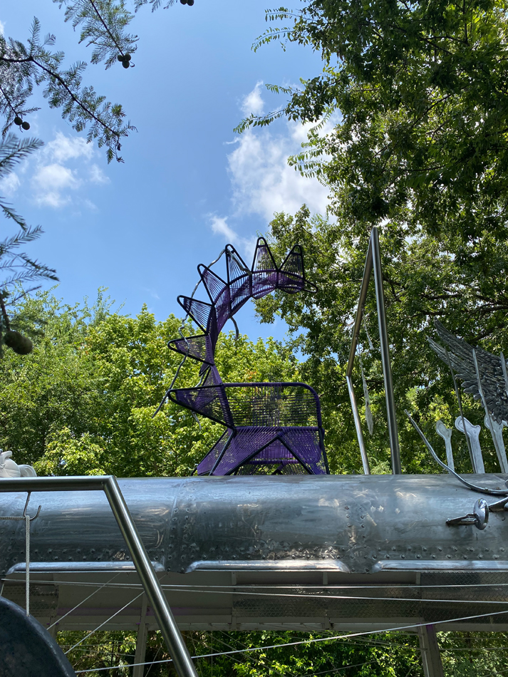 Biomorphic metallic sculptural elements, including a throne, made from found materials and attached to a chrome bus. Detail of Guadalape Maravilla's interactive, kinetic bus sculpture Mariposa Relampago.