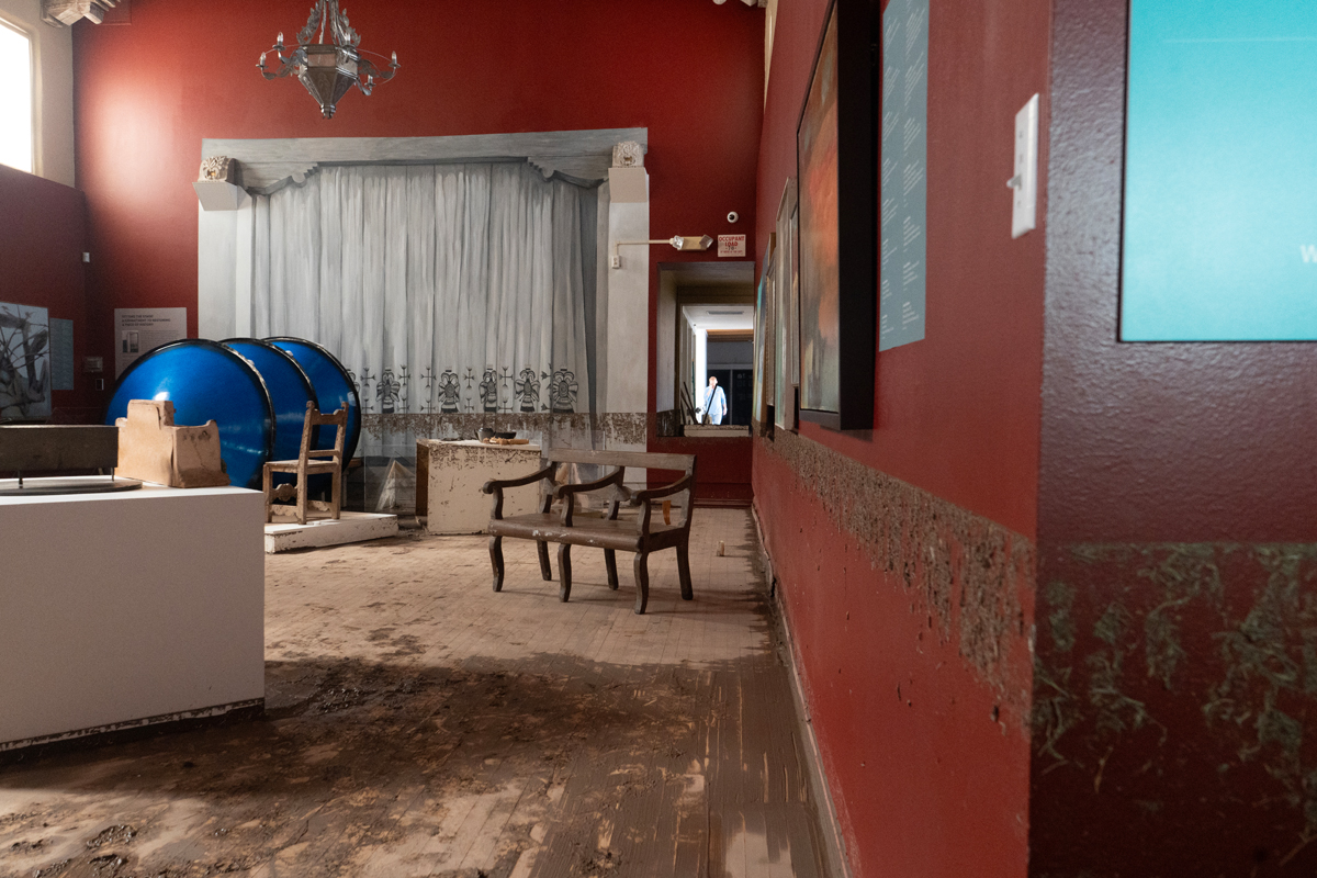 Muddy furniture and a visible flood water line.