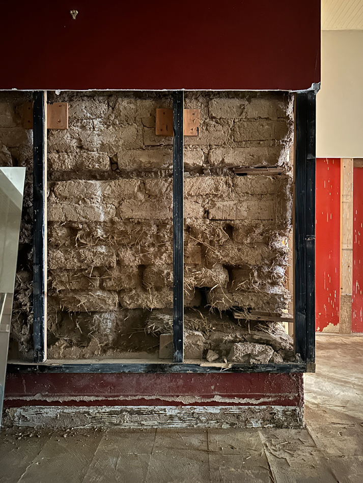 A gutted wall in Roswell Museum exposes its original adobe bricks.