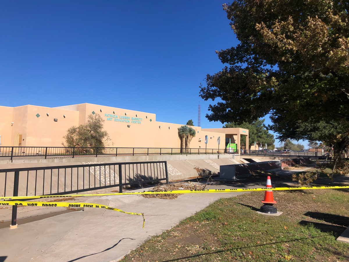 Caution tape stretched across a path near a concrete channel that overflowed in Roswell, New Mexico. View imagery and read stories from the Roswell Museum flood.