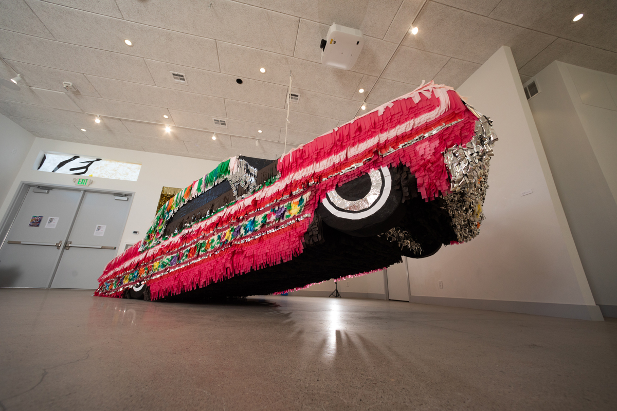 A cut-paper car in the style of a piñata by Justin Favela, on view at Nuwu Art. Curated by Fawn Douglas.