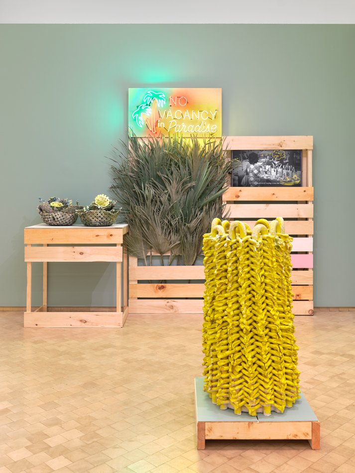 Mixed media installation in a palette of yellow, green, and brown. Curated by Maria Elena Ortiz.