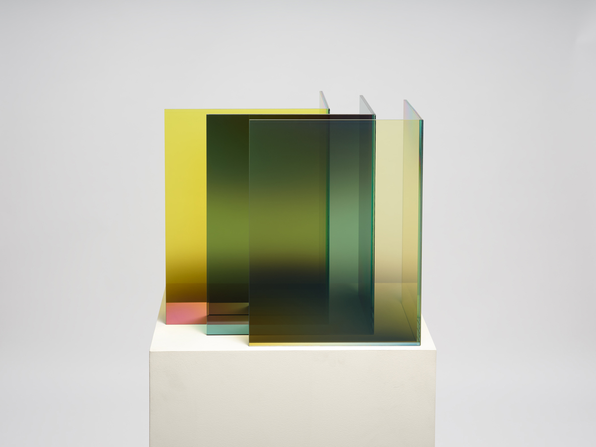 Laminated glass sculpture in yellow and green by Larry Bell featuring vertical forms aligned at a shared right angle.