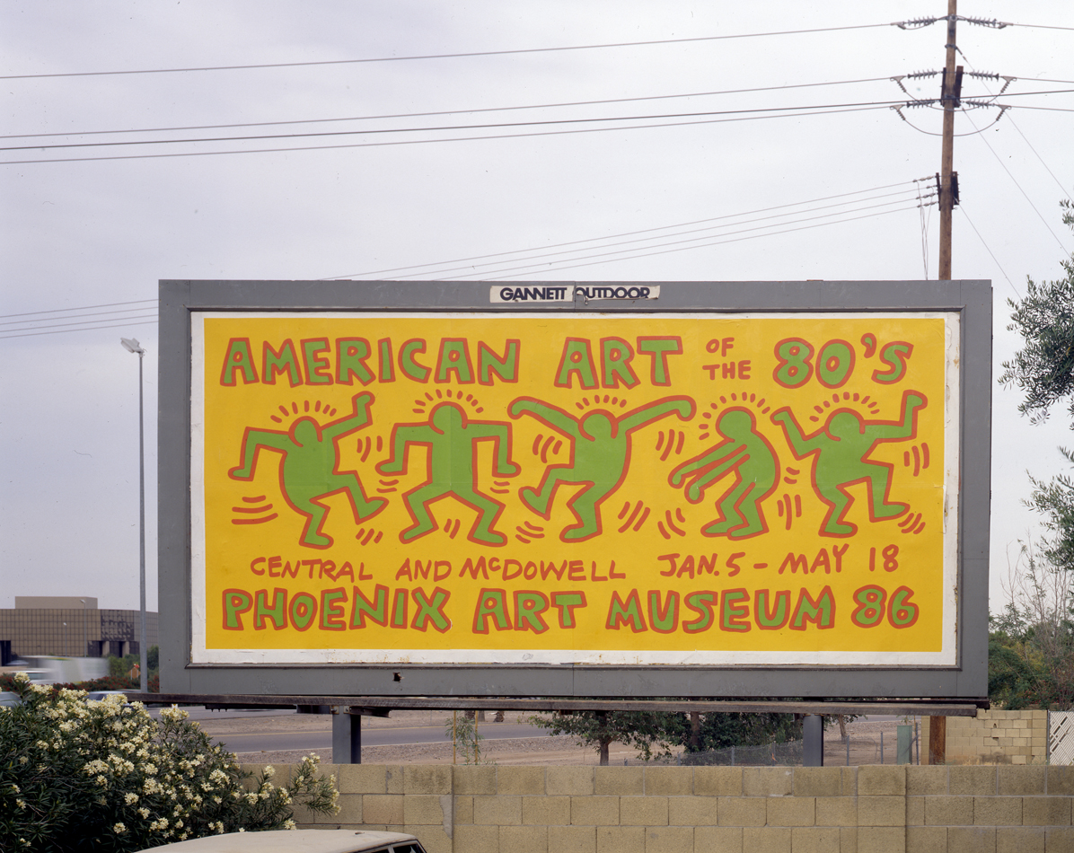 Yellow, red, and turquoise billboard designed by Keith Haring for a 1980s art exhibition at Phoenix Art Museum.