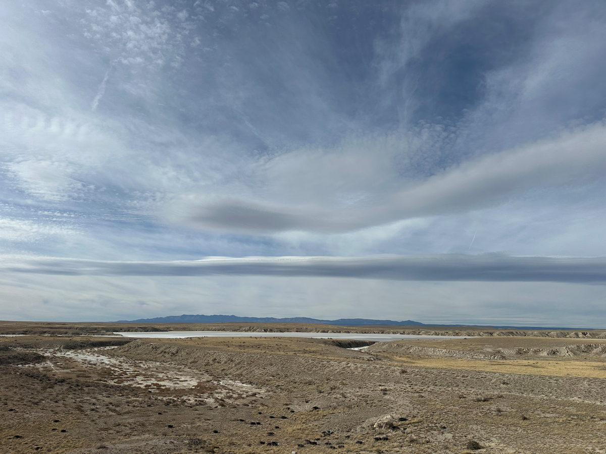 The salty remnants of a Pleistocene lake in New Mexico, with mountains and low clouds in the distance.