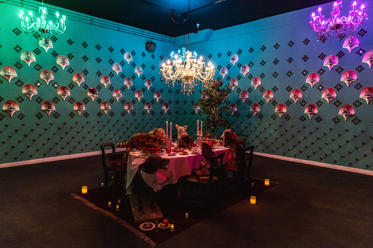 Art installation showing a group of taxidermied animals feasting at a banquet table. Tracing the path and influences of Park City curator Nancy Stoaks.