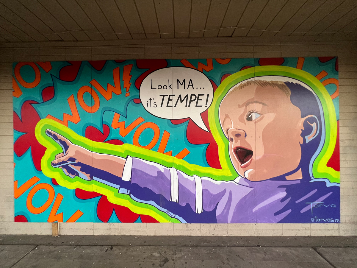 A colorful mural in a pop art style of a child pointing, with a speech bubble that reads "Look MA... it's TEMPE!"