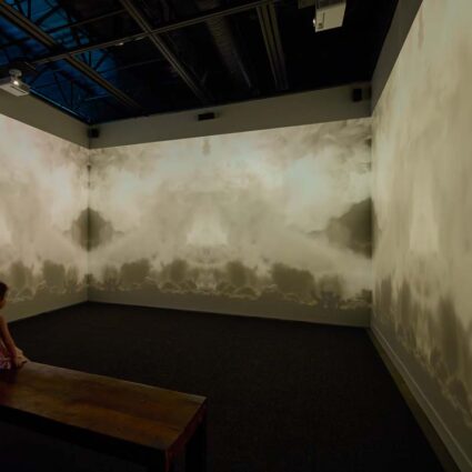 Video installation on three walls of nuclear tests by Cara Despain.