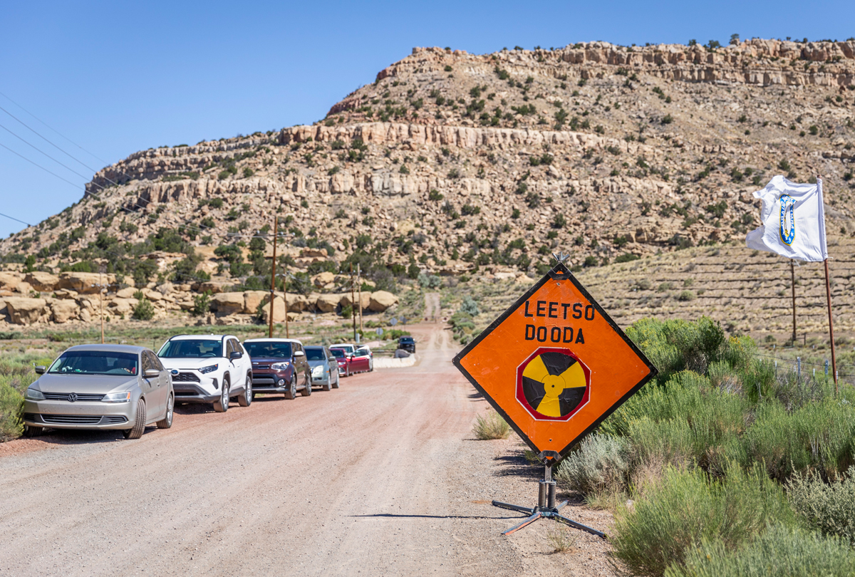 New Mexico hillside with a bright orange sign that reads "LEETSOH DOODA," or "NO URANIUM." Photo by Shayla Blatchford for the Anti-Uranium Mapping Project.