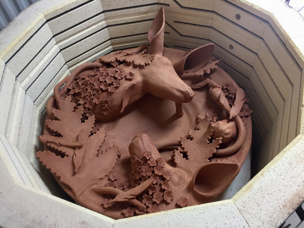 Intricate ceramic artwork in a kiln by Farraday Newsome.