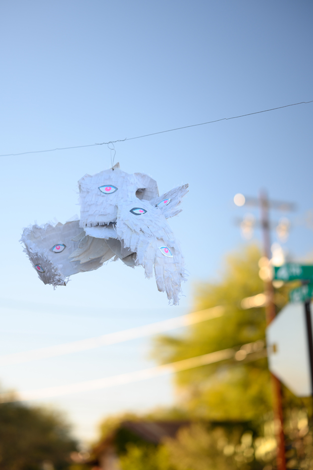 A winged piñata sculpture watches over the inaugural Urgent Care Art event.