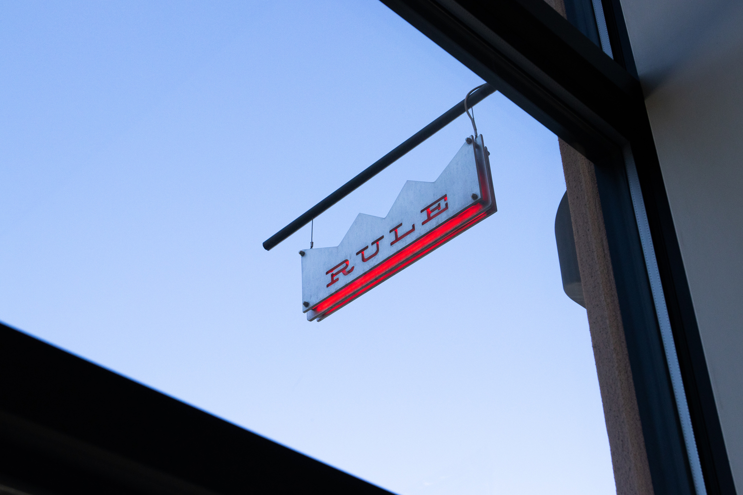 A silver and red sign that reads RULE. Rule Gallery Denver is leaving its Santa Fe Drive location.