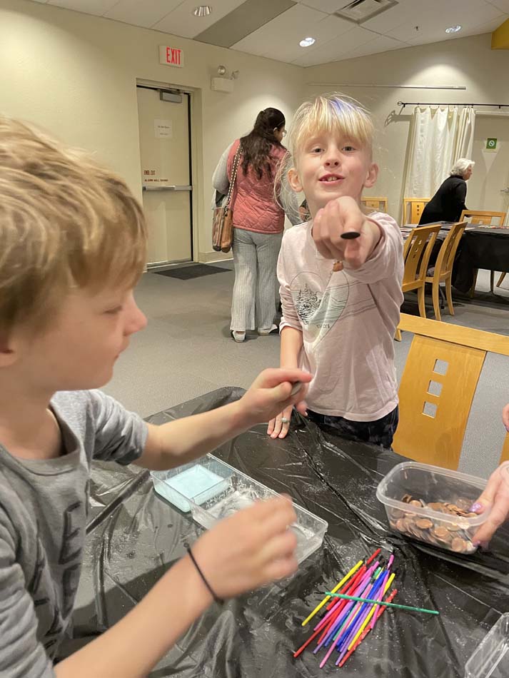 The author's children showing off their shiny pennies, after scrubbing off the corrosion with salt and vinegar.