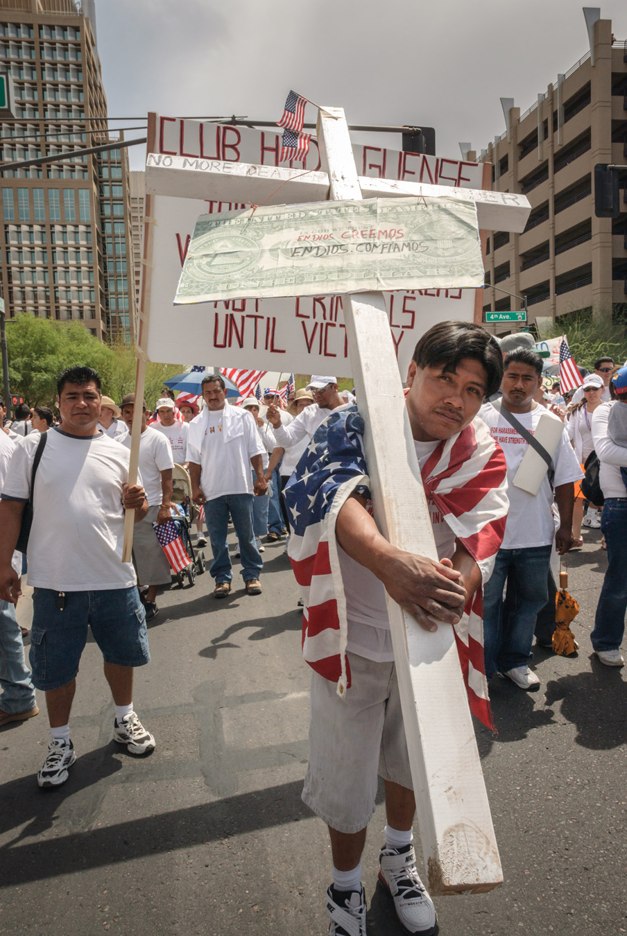 An activist carries a cross in support of immigrant rights in Phoenix.