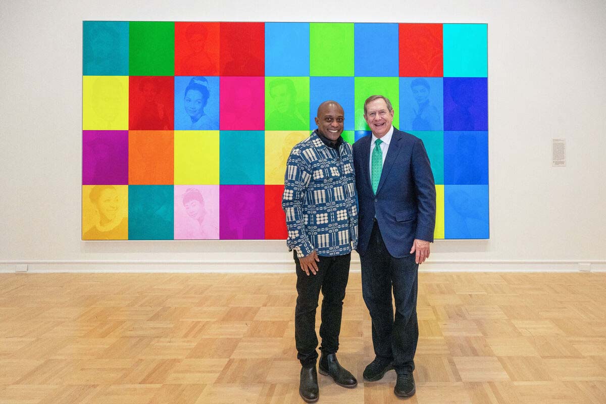 Hank Willis Thomas (left) and Jordan Schnitzer stand in front of Thomas's piece <i>An All Colored Cast</i>, which is part of the <i>LOVERULES</i> exhibition at the University of Arizona Museum of Art.