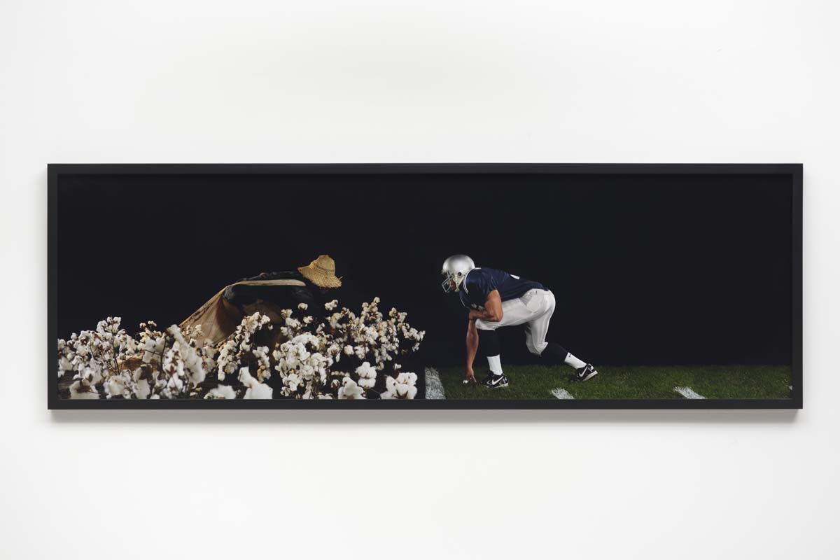 Photograph with a Black football player facing off with a cotton picker.
