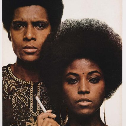 a digital chromogenic print of a Black woman and man, side by side, him in an embroidered dashiki, her with an afro and a cigarette
