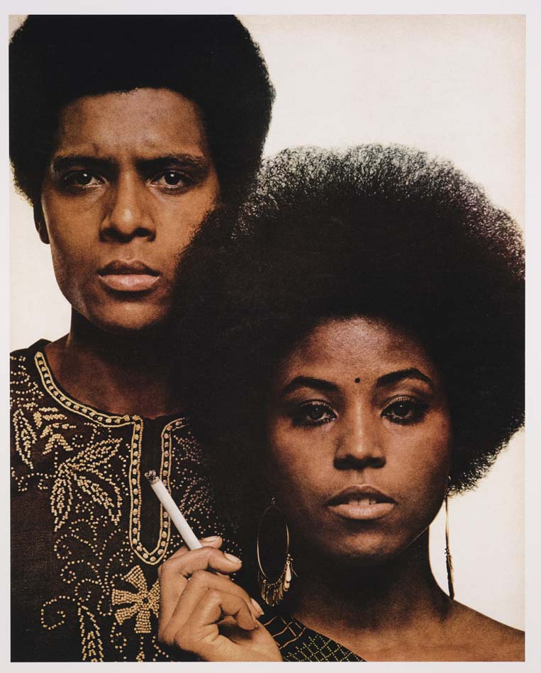 a digital chromogenic print of a Black woman and man, side by side, him in an embroidered dashiki, her with an afro and a cigarette