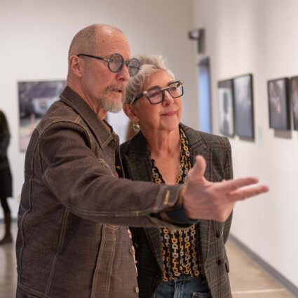 Two people looking at photography Inside Center’s new exhibition space.