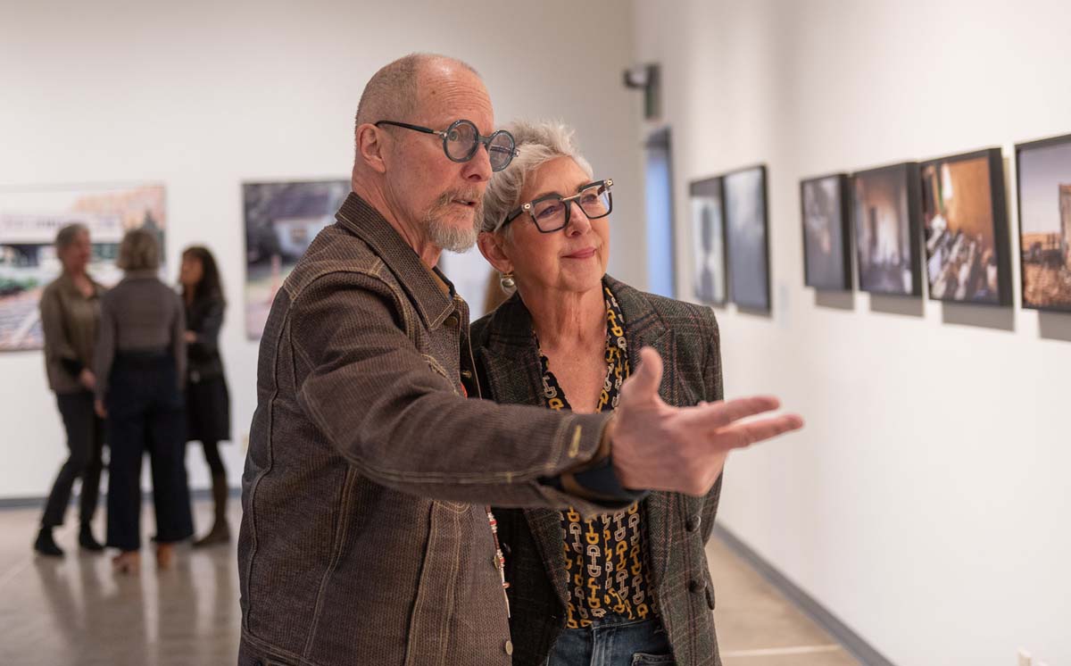 Two people looking at photography Inside Center’s new exhibition space.