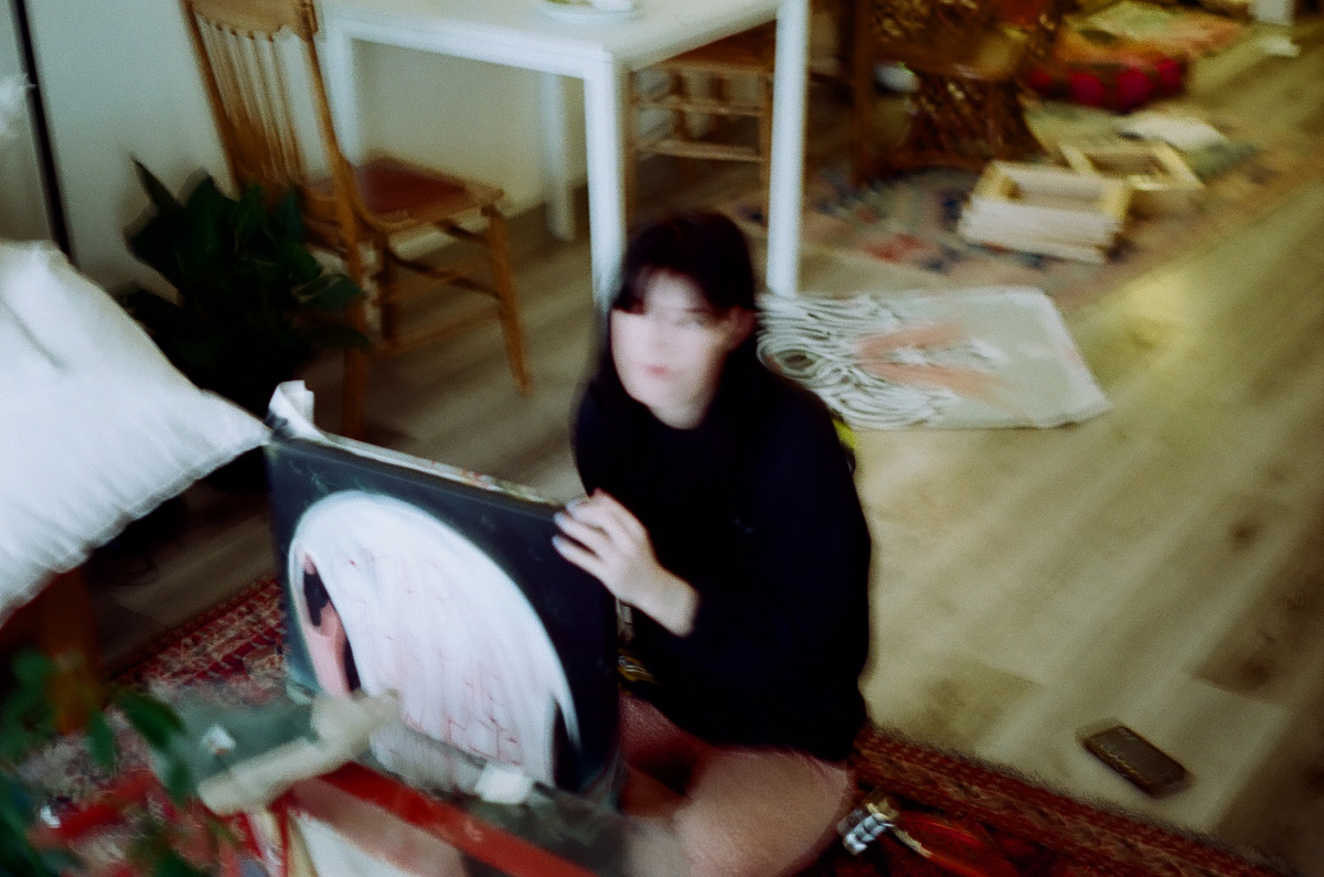 Blurry still of Colorado artist Grace Kennison holding a painting.