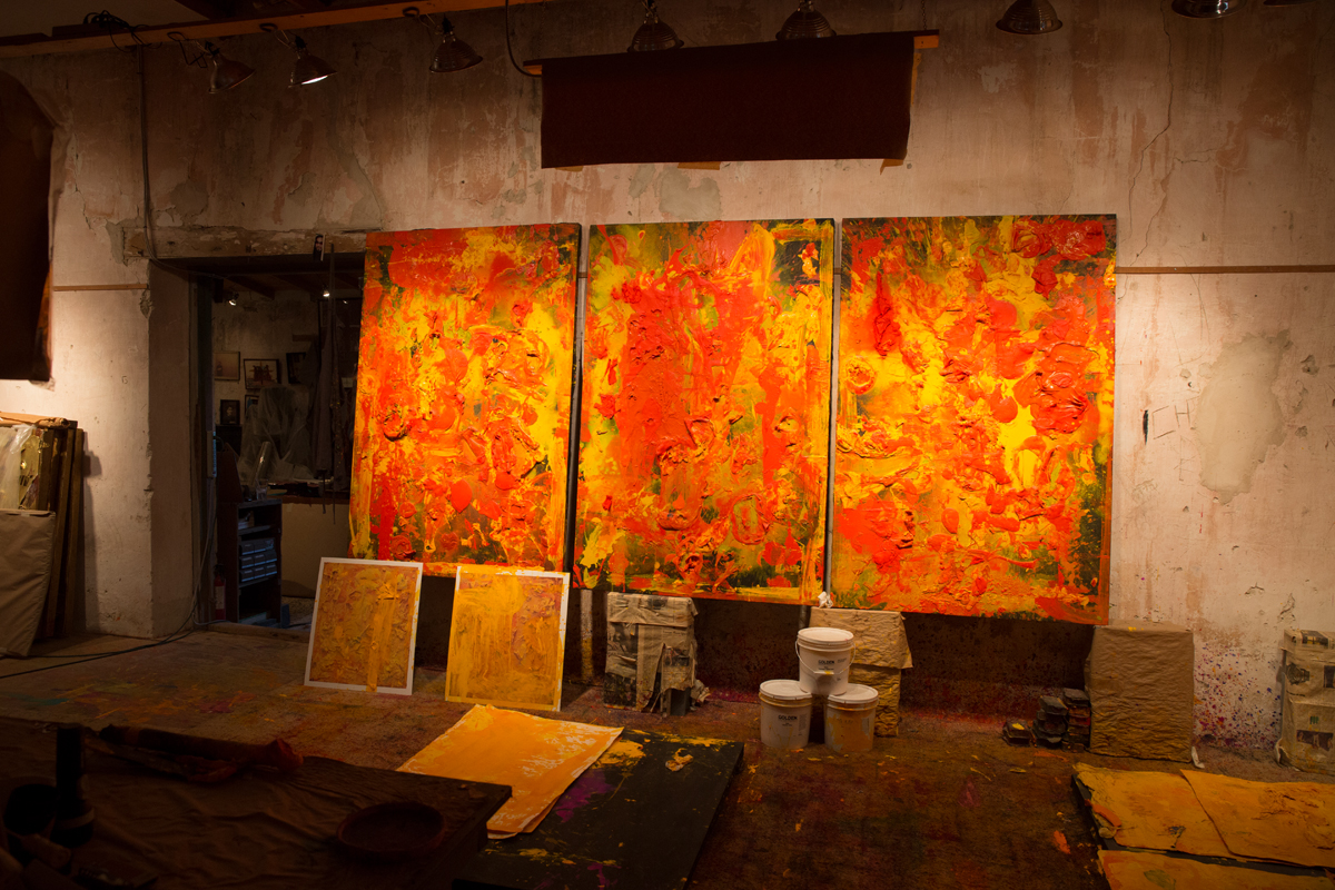 Three abstract paintings by Michael Tracy in orange, yellow, and red.