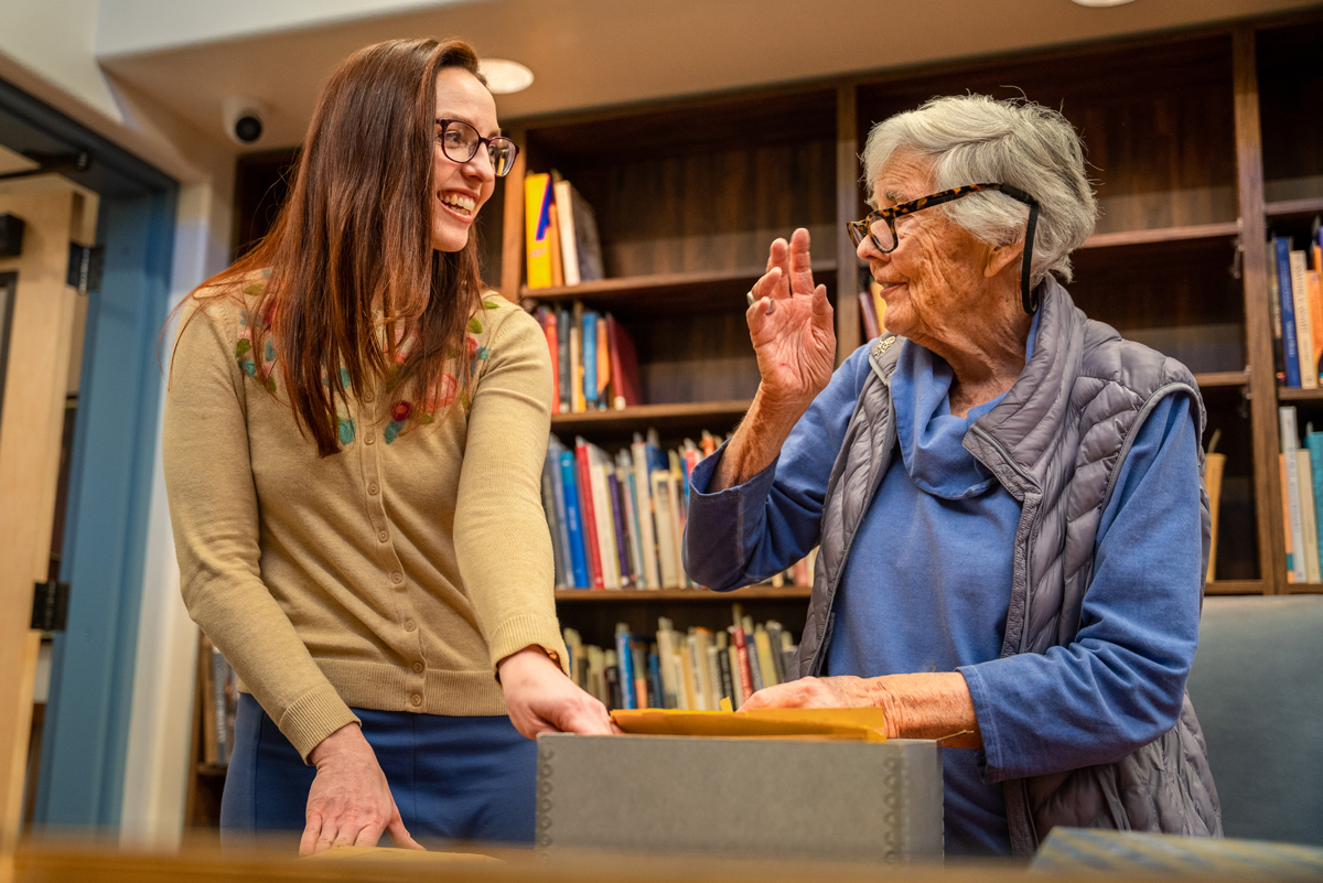 The director of Couse-Sharp Historic Site digs through archival materials with a descendant of Eanger Irving Couse.