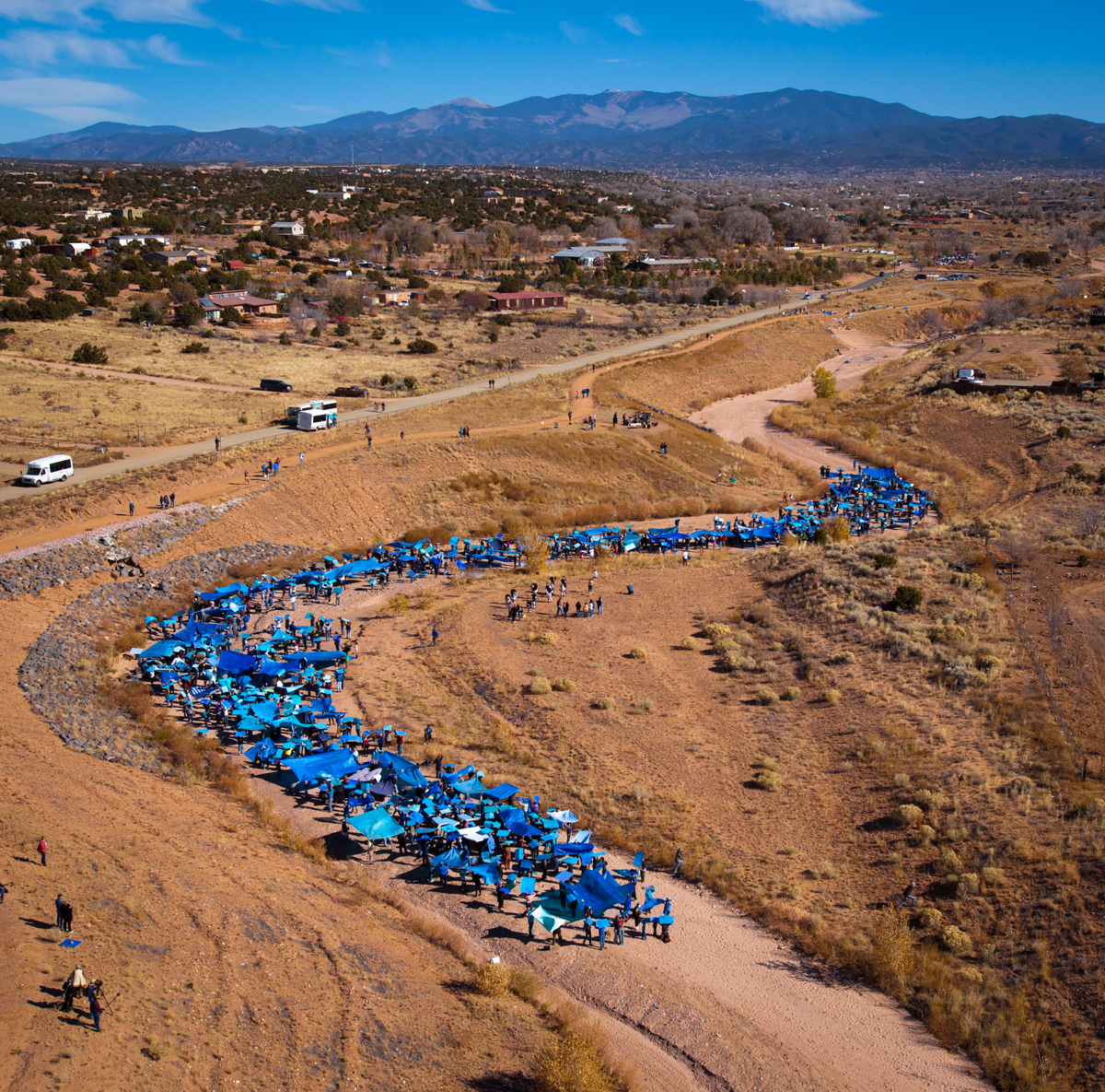 A bright-blue river of people reenacts a flash flood in Santa Fe, NM.