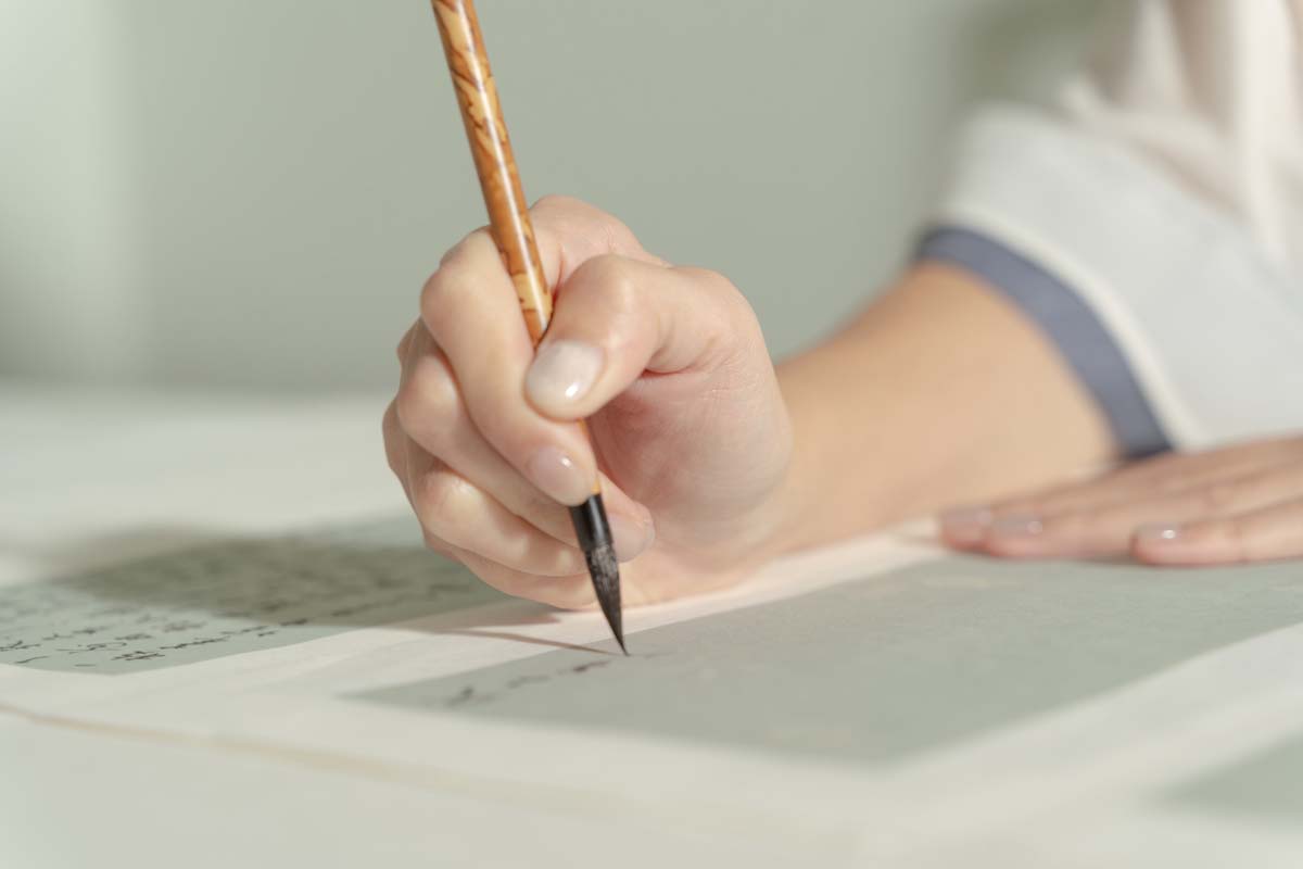 Close up of the hand of artist Lu Wei drawing calligraphy