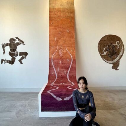 Lu Wei with a monumental scroll that hangs from the main wall of Material gallery in Salt Lake City.