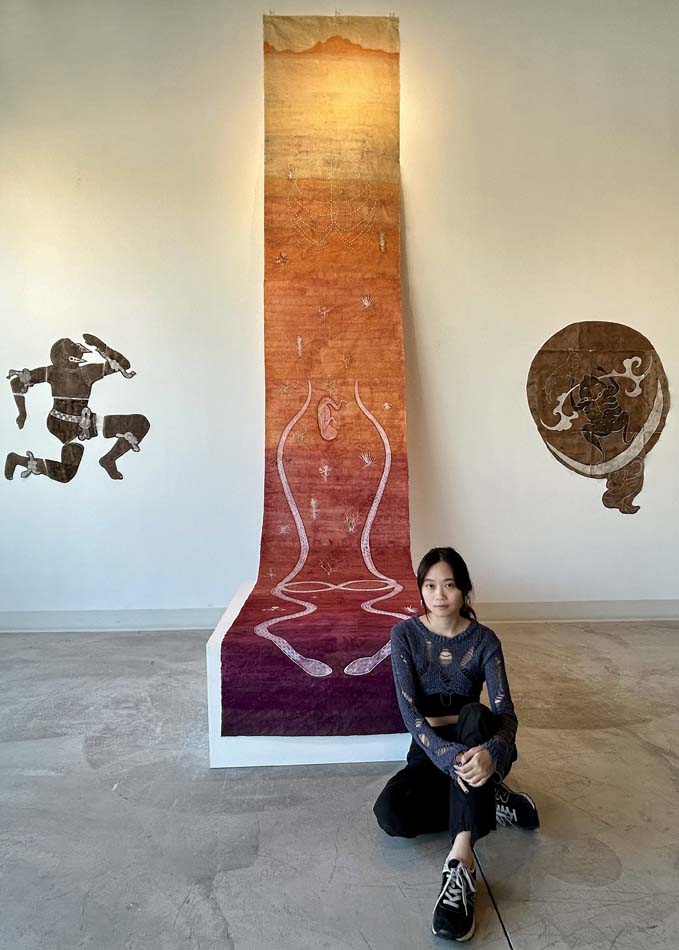 Lu Wei with a monumental scroll that hangs from the main wall of Material gallery in Salt Lake City.