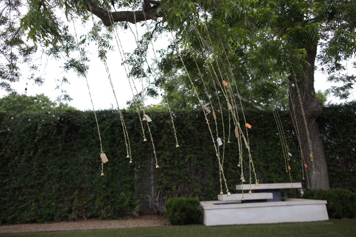 Bells and messages hanging on jute twine in a courtyard at Women & Their Work