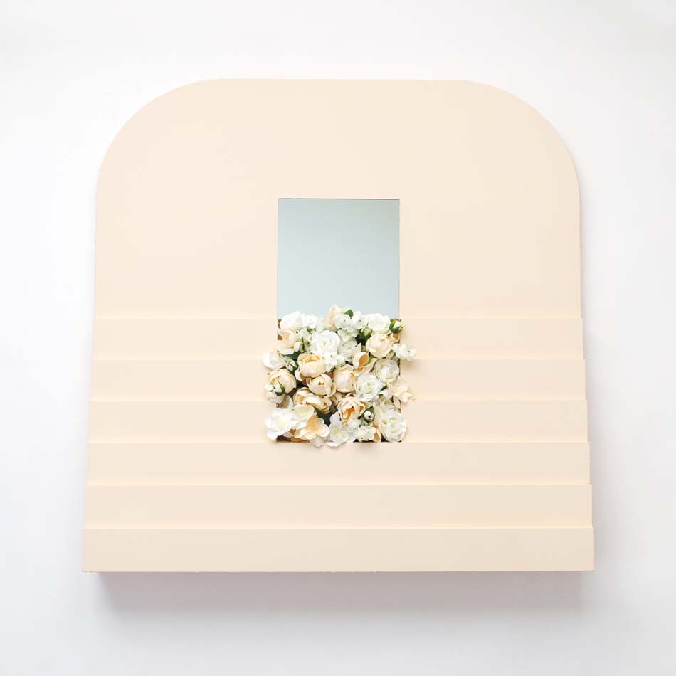 Sculpture by Michael Afsa, with rounded edges and an aperture with flowers in the middle.