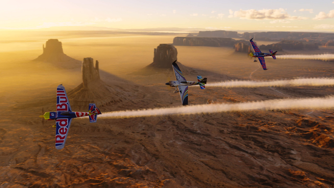 Three prop planes, including a Red Bull plane, soar over Monument Valley in Microsoft Flight Simulator. Southwest video games rival traditional landscape art in their depictions of the region.