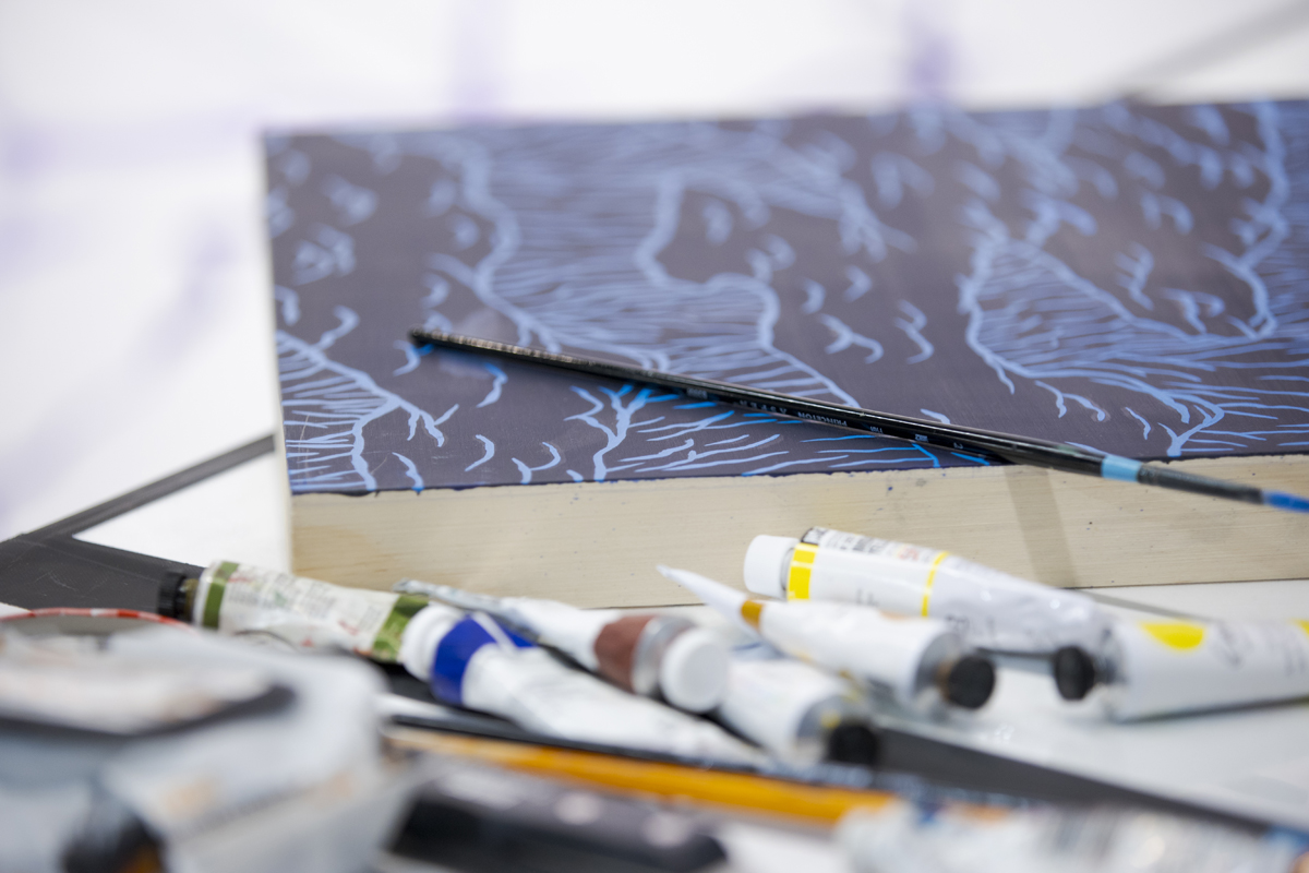 A painting and artistic tools and mediums in the Arizona studio of Steven J. Yazzie.