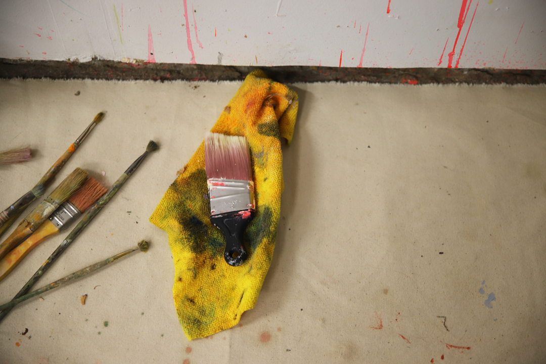 A used paintbrush on a yellow rag.