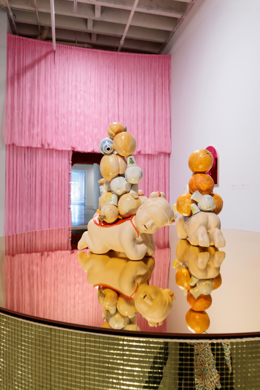 Detail of an installation work by Jennifer Ling Datchuk, featuring porcelain figures on a mirrored gold disco platform.